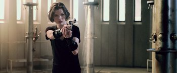 Movie still from “Resident Evil: Afterlife” (2010), directed by Paul W.S. Anderson – A woman in a black shirt holding a gun; Medium shot, Low angle