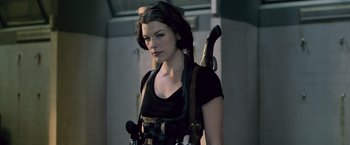 Movie still from “Resident Evil: Afterlife” (2010), directed by Paul W.S. Anderson – A woman with a gun in her hand and a knife in her other hand; Medium shot, Low angle