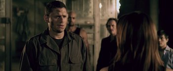 Movie still from “Resident Evil: Afterlife” (2010), directed by Paul W.S. Anderson – A group of men standing next to each other in a room; Close Up shot, Over the shoulder angle