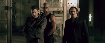 Movie still from “Resident Evil: Afterlife” (2010), directed by Paul W.S. Anderson – A group of men standing next to each other in a room; Medium shot, Low angle