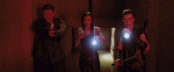Movie still from “Resident Evil: Afterlife” (2010), directed by Paul W.S. Anderson – A group of people holding guns in a room; Medium shot, Low angle