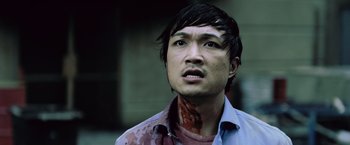 Movie still from “Resident Evil: Afterlife” (2010), directed by Paul W.S. Anderson – A young man with a bloody neck and face; Close Up shot, High angle