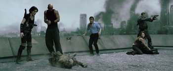 Movie still from “Resident Evil: Afterlife” (2010), directed by Paul W.S. Anderson – Two men standing over a dead body on the roof of a building; Wide shot, Low angle