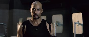 Movie still from “Resident Evil: Afterlife” (2010), directed by Paul W.S. Anderson – A man with a bald head wearing a black shirt; Close Up shot, Low angle