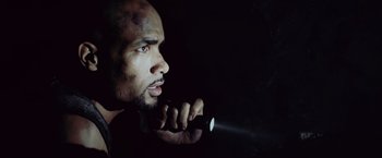 Movie still from “Resident Evil: Afterlife” (2010), directed by Paul W.S. Anderson – A man holding a flashlight up to his face; Close Up shot, Overhead angle