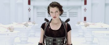 Movie still from “Resident Evil: Afterlife” (2010), directed by Paul W.S. Anderson – A woman in black shirt and black pants; Medium shot, Low angle