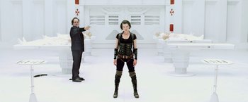 Movie still from “Resident Evil: Afterlife” (2010), directed by Paul W.S. Anderson – A man and a woman standing next to each other in a room; Medium shot, Low angle