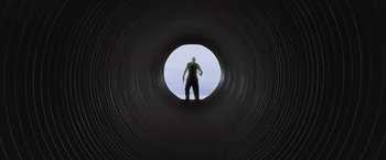 Movie still from “Resident Evil: Afterlife” (2010), directed by Paul W.S. Anderson – A man standing inside of a pipe looking out at the sky; Extreme Wide shot, Low angle