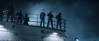 Movie still from “Resident Evil: Apocalypse” (2004), directed by Alexander Witt – A group of men standing on top of a metal fence; Wide shot, Low angle