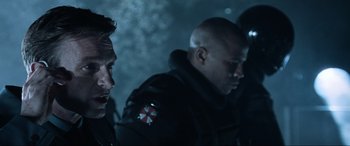 Movie still from “Resident Evil: Apocalypse” (2004), directed by Alexander Witt – A group of men standing next to each other in the dark; Close Up shot, Over the shoulder angle