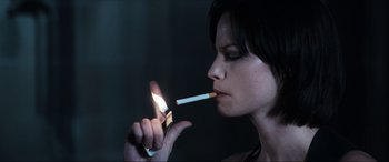 Movie still from “Resident Evil: Apocalypse” (2004), directed by Alexander Witt – A woman is lighting a cigarette with a match; Close Up shot, High angle