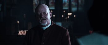 Movie still from “Resident Evil: Apocalypse” (2004), directed by Alexander Witt – A man with a beard wearing a priest's outfit; Close Up shot, Low angle