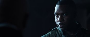 Movie still from “Resident Evil: Apocalypse” (2004), directed by Alexander Witt – A person wearing a military uniform; Close Up shot, Over the shoulder angle