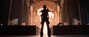 Movie still from “Resident Evil: Apocalypse” (2004), directed by Alexander Witt – A man standing in front of an open fire; Wide shot, Low angle