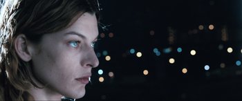 Movie still from “Resident Evil: Apocalypse” (2004), directed by Alexander Witt – A woman's face at night with lights in the background; Close Up shot, Low angle