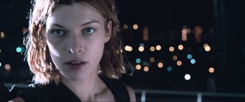Movie still from “Resident Evil: Apocalypse” (2004), directed by Alexander Witt – A person with a city in the background; Close Up shot, Low angle