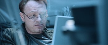 Movie still from “Resident Evil: Apocalypse” (2004), directed by Alexander Witt – A man with glasses is looking at a laptop; Close Up shot, Low angle