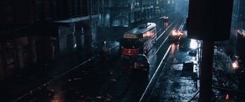 Movie still from “Resident Evil: Apocalypse” (2004), directed by Alexander Witt – A red and white train traveling down train tracks in the rain; Extreme Wide shot, High angle