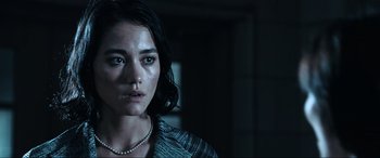 Movie still from “Resident Evil: Apocalypse” (2004), directed by Alexander Witt – A woman with a necklace is staring at the camera; Close Up shot, Low angle