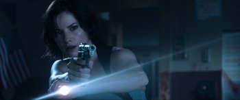 Movie still from “Resident Evil: Apocalypse” (2004), directed by Alexander Witt – A woman is holding a gun and aiming it; Close Up shot, Over the shoulder angle