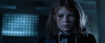 Movie still from “Resident Evil: Apocalypse” (2004), directed by Alexander Witt – A young girl with long hair and a bow tie; Close Up shot, Low angle