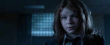 Movie still from “Resident Evil: Apocalypse” (2004), directed by Alexander Witt – A young girl with long hair wearing a suit and tie; Close Up shot, Over the shoulder angle