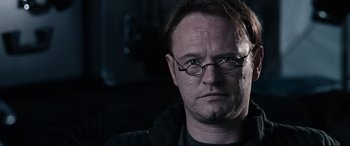 Movie still from “Resident Evil: Apocalypse” (2004), directed by Alexander Witt – A person wearing glasses and a sweater; Close Up shot, Low angle