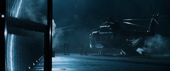 Movie still from “Resident Evil: Apocalypse” (2004), directed by Alexander Witt – A group of men standing next to an army helicopter; Wide shot, Over the shoulder angle