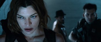 Movie still from “Resident Evil: Apocalypse” (2004), directed by Alexander Witt – A person wearing a hat; Close Up shot, Over the shoulder angle