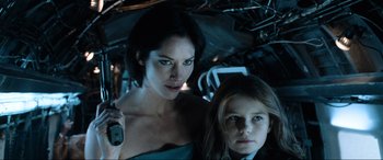 Movie still from “Resident Evil: Apocalypse” (2004), directed by Alexander Witt – A woman and a girl are standing next to each other; Close Up shot, Low angle