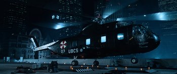 Movie still from “Resident Evil: Apocalypse” (2004), directed by Alexander Witt – An umbrella corporation helicopter parked in a parking lot at night; Extreme Wide shot, Overhead angle