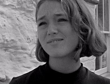 Movie still from “Bait” (2019), directed by Mark Jenkin – A young woman is smiling for the camera; Close Up shot, Low angle