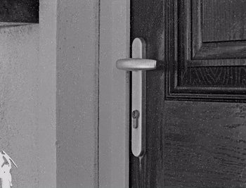 Movie still from “Bait” (2019), directed by Mark Jenkin – A black and white photo of a door handle; Extreme Close Up shot, High angle