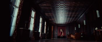 Movie still from “Resident Evil: Extinction” (2007), directed by Russell Mulcahy – A woman in a red dress is dancing in a dark room; Extreme Wide shot, Low angle