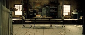 Movie still from “Resident Evil: Extinction” (2007), directed by Russell Mulcahy – An empty room with two chairs and a table; Wide shot, High angle