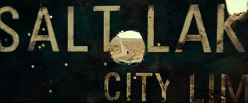 Movie still from “Resident Evil: Extinction” (2007), directed by Russell Mulcahy – A view through a hole in a wall of a street sign; Extreme Close Up shot, Low angle
