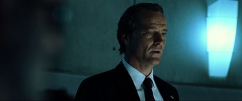 Movie still from “Resident Evil: Extinction” (2007), directed by Russell Mulcahy – A person wearing a suit and tie; Close Up shot, Low angle