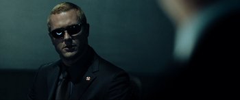 Movie still from “Resident Evil: Extinction” (2007), directed by Russell Mulcahy – A man wearing a suit and sunglasses in the dark; Close Up shot, Over the shoulder angle