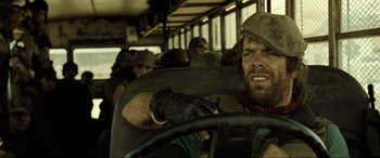 Movie still from “Resident Evil: Extinction” (2007), directed by Russell Mulcahy – A man riding in a bus on the side of the road; Close Up shot, Over the shoulder angle