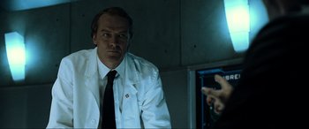 Movie still from “Resident Evil: Extinction” (2007), directed by Russell Mulcahy – A man in a white lab coat standing in front of a mirror; Close Up shot, Low angle