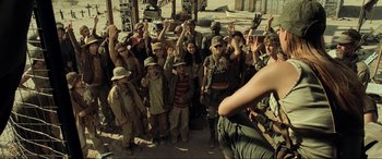 Movie still from “Resident Evil: Extinction” (2007), directed by Russell Mulcahy – A group of people standing next to each other on a dirt ground; Wide shot, High angle