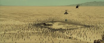 Movie still from “Resident Evil: Extinction” (2007), directed by Russell Mulcahy – A helicopter flying over a large group of people in the desert; Extreme Wide shot, High angle