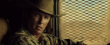Movie still from “Resident Evil: Extinction” (2007), directed by Russell Mulcahy – A man wearing a cowboy hat sitting in a vehicle; Close Up shot, Over the shoulder angle