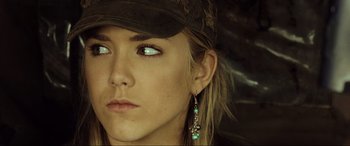 Movie still from “Resident Evil: Extinction” (2007), directed by Russell Mulcahy – A person wearing a hat and earrings; Close Up shot, Over the shoulder angle