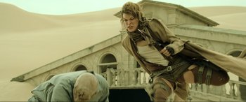 Movie still from “Resident Evil: Extinction” (2007), directed by Russell Mulcahy – A woman is running while holding a gun; Medium shot, Low angle
