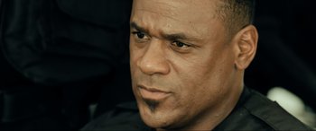 Movie still from “Resident Evil: Extinction” (2007), directed by Russell Mulcahy – A man's face in a black shirt; Close Up shot, Low angle