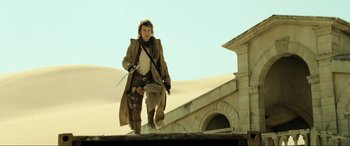Movie still from “Resident Evil: Extinction” (2007), directed by Russell Mulcahy – A man in a trench coat holding a sword in his hand; Wide shot, Low angle