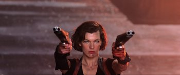 Movie still from “Resident Evil: Retribution” (2012), directed by Paul W.S. Anderson – A woman holding two pistols up to her face; Medium shot, Low angle