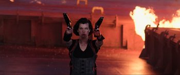 Movie still from “Resident Evil: Retribution” (2012), directed by Paul W.S. Anderson – A woman holding two pistols in her hands; Medium shot, Low angle