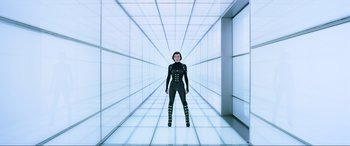 Movie still from “Resident Evil: Retribution” (2012), directed by Paul W.S. Anderson – A woman standing in a room with a white wall; Wide shot, Low angle